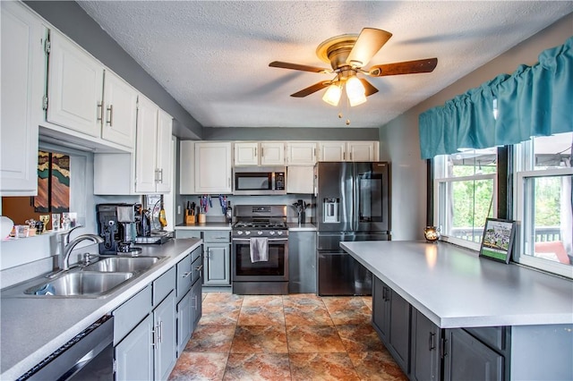 kitchen with sink, white cabinets, a textured ceiling, and appliances with stainless steel finishes