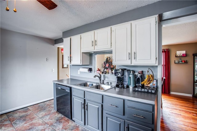 kitchen featuring stainless steel dishwasher, a textured ceiling, sink, light hardwood / wood-style flooring, and white cabinetry