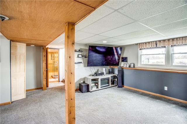 basement featuring a paneled ceiling and carpet