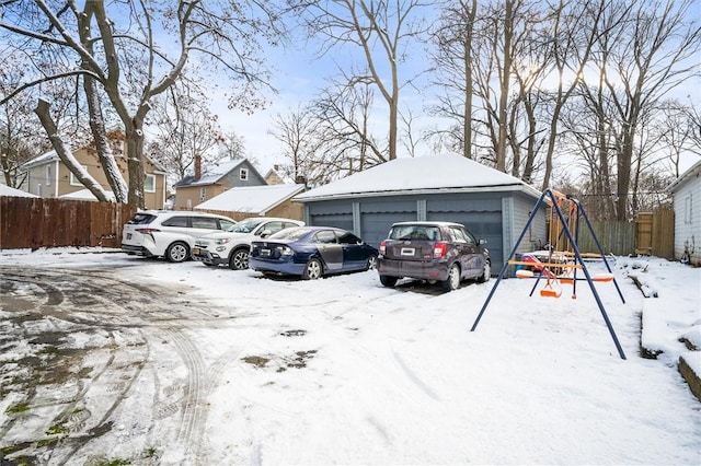 snow covered parking area featuring a garage