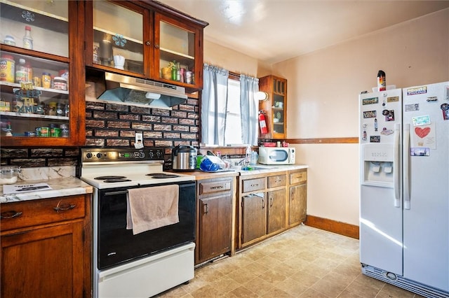 kitchen featuring white appliances, sink, and range hood