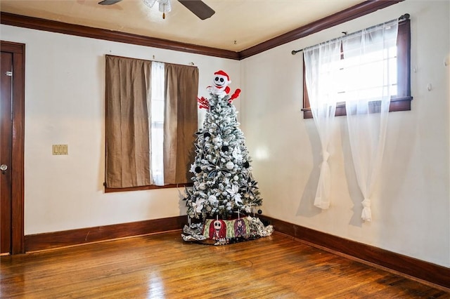 spare room with crown molding, plenty of natural light, and hardwood / wood-style floors