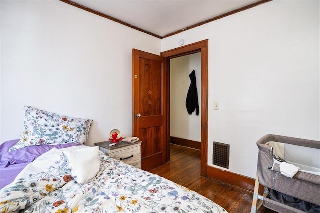 bedroom featuring dark hardwood / wood-style floors and crown molding