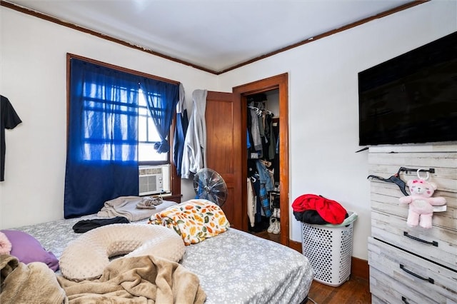 bedroom featuring cooling unit, dark hardwood / wood-style flooring, crown molding, and a closet