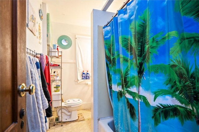 bathroom featuring shower / tub combo and toilet