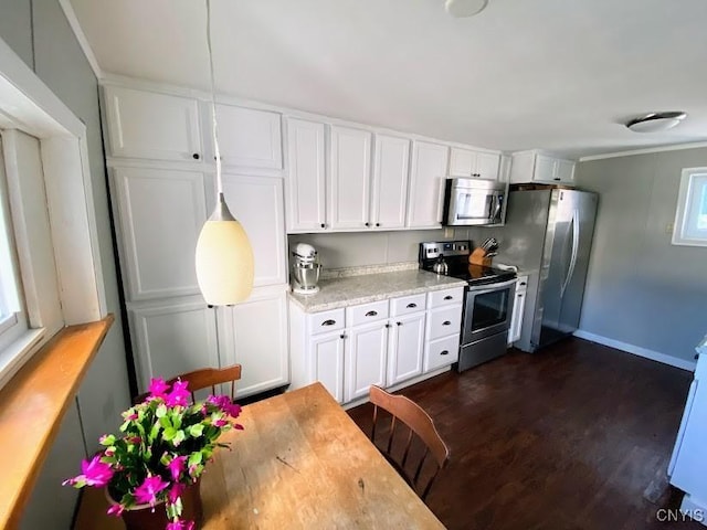 kitchen featuring crown molding, white cabinetry, dark wood-type flooring, and appliances with stainless steel finishes