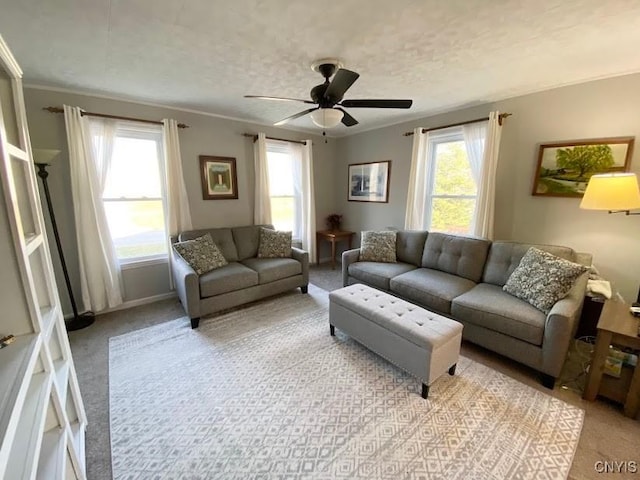 living room featuring ceiling fan, light colored carpet, and crown molding