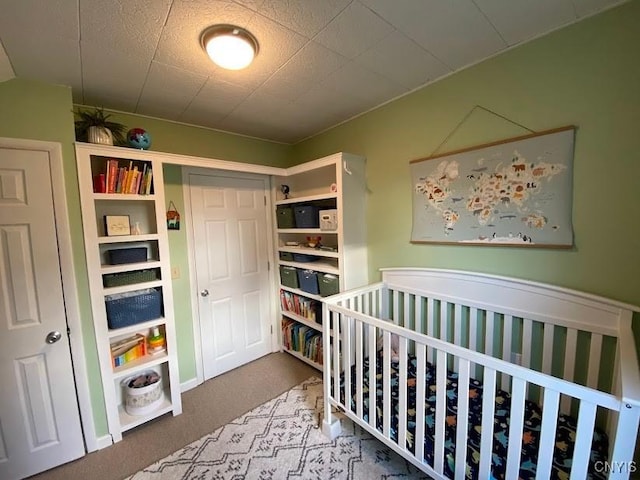 bedroom featuring carpet and a nursery area