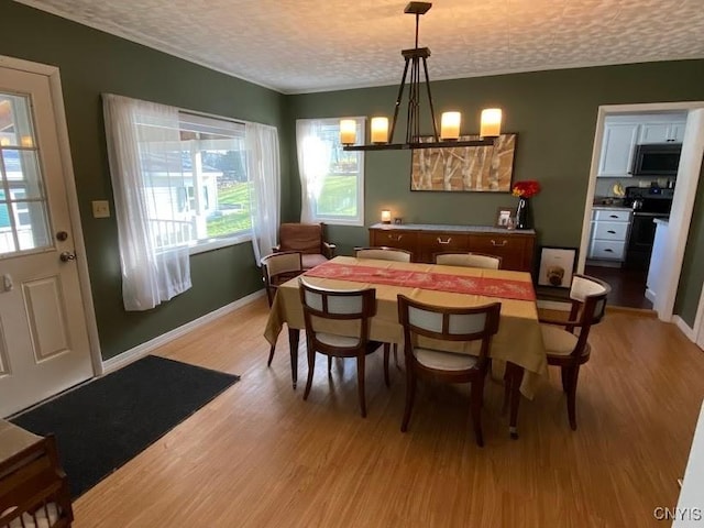 dining space featuring a textured ceiling and light wood-type flooring