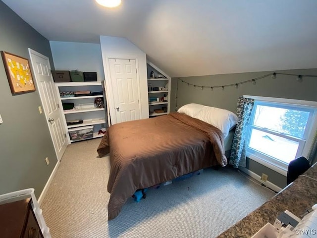 carpeted bedroom with lofted ceiling