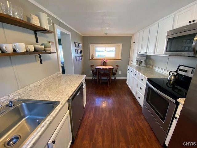 kitchen featuring ornamental molding, stainless steel appliances, dark wood-type flooring, sink, and white cabinetry