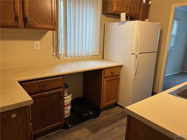 kitchen with dark hardwood / wood-style flooring, white fridge, and built in desk