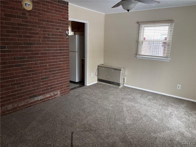 carpeted spare room with ceiling fan, ornamental molding, and heating unit