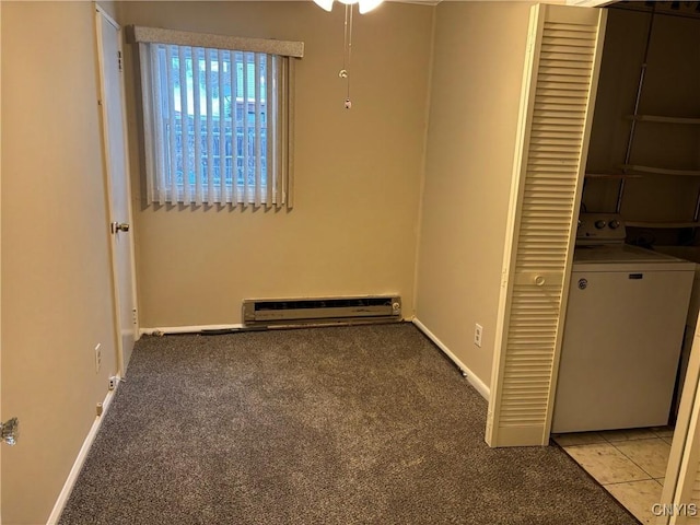 carpeted spare room with baseboard heating and washer / clothes dryer