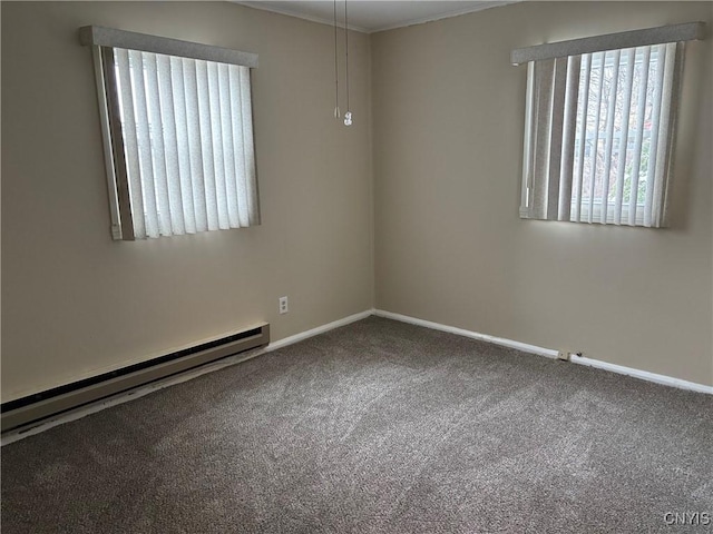 carpeted spare room featuring ornamental molding and a baseboard heating unit