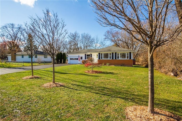 ranch-style home with a garage and a front lawn