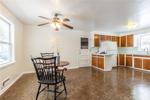 kitchen with sink, white fridge, a wealth of natural light, and ceiling fan