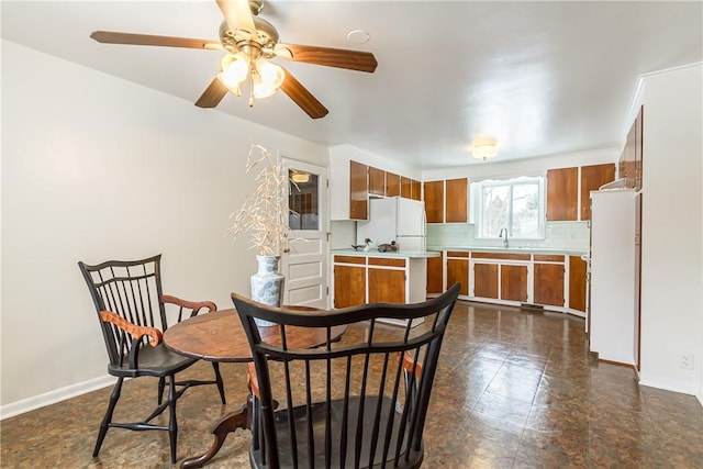 dining area featuring ceiling fan and sink