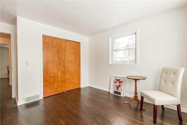 sitting room with dark wood-type flooring