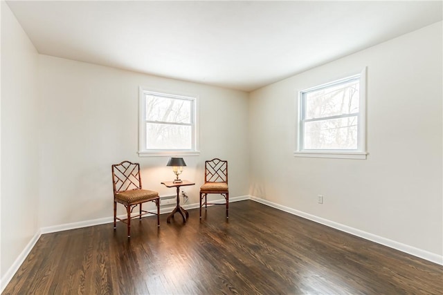 living area featuring a healthy amount of sunlight and dark hardwood / wood-style floors