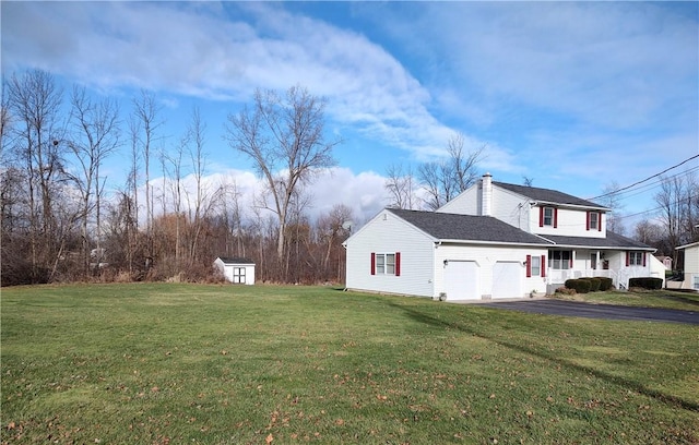 view of side of property featuring a lawn, a storage unit, a porch, and a garage