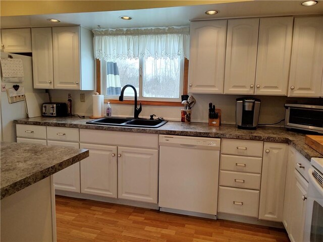 kitchen with white cabinets, white appliances, and sink