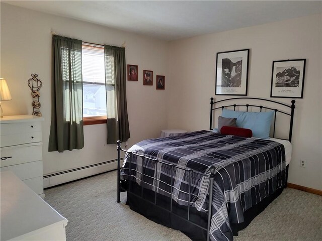 bedroom featuring light carpet and a baseboard heating unit