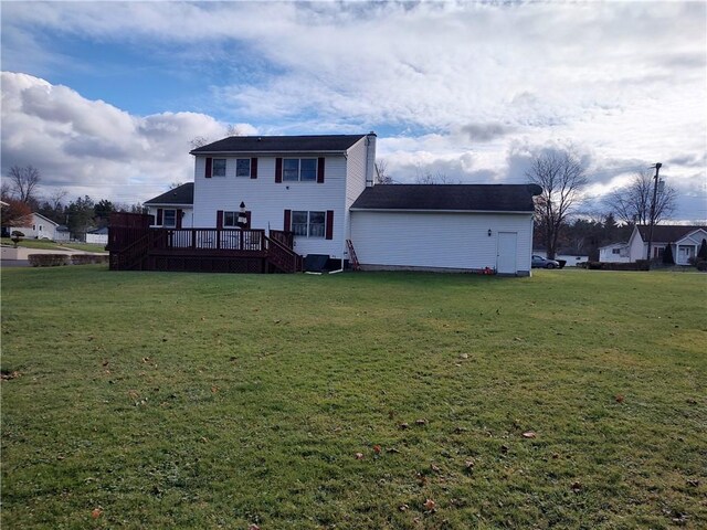 rear view of property featuring a yard and a wooden deck