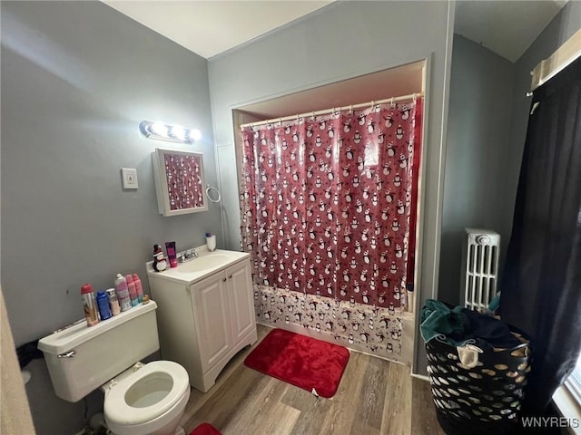 full bathroom with vanity, radiator, shower / bath combination with curtain, hardwood / wood-style flooring, and toilet