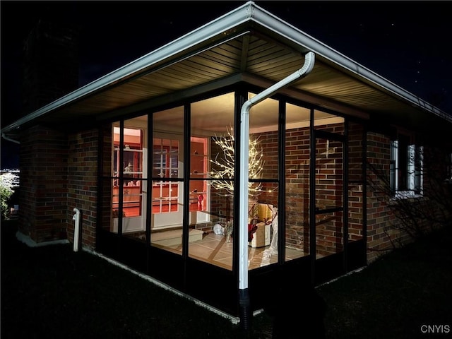 property exterior at night featuring a sunroom