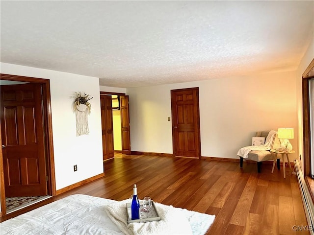 interior space with hardwood / wood-style floors, a textured ceiling, and a baseboard radiator