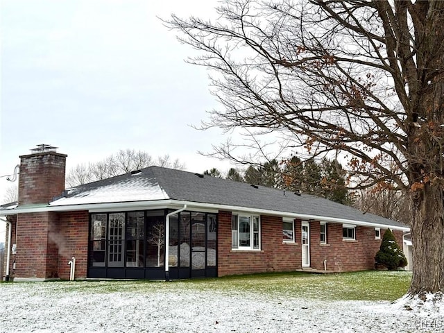 rear view of property with a yard and a sunroom