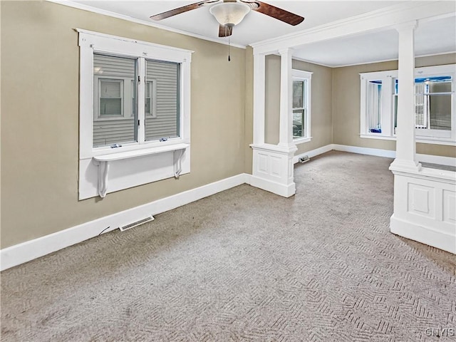 unfurnished room with ceiling fan, crown molding, light carpet, and decorative columns