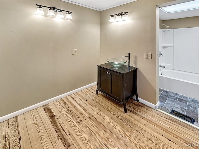 bathroom with vanity, hardwood / wood-style flooring, shower / bathtub combination, and crown molding