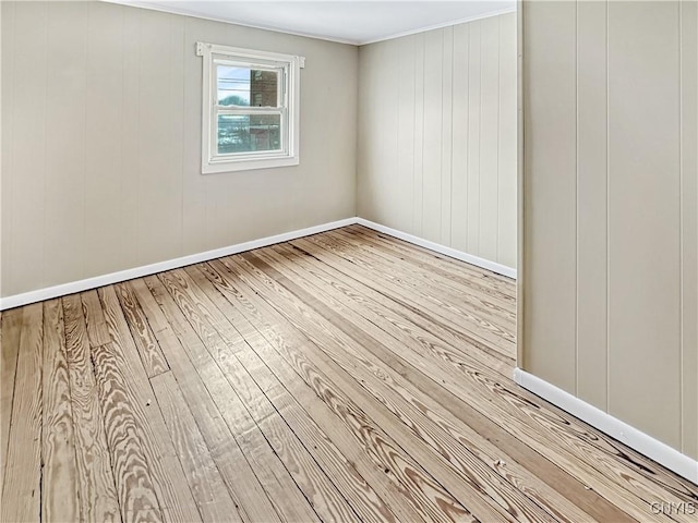 unfurnished room with light wood-type flooring and crown molding