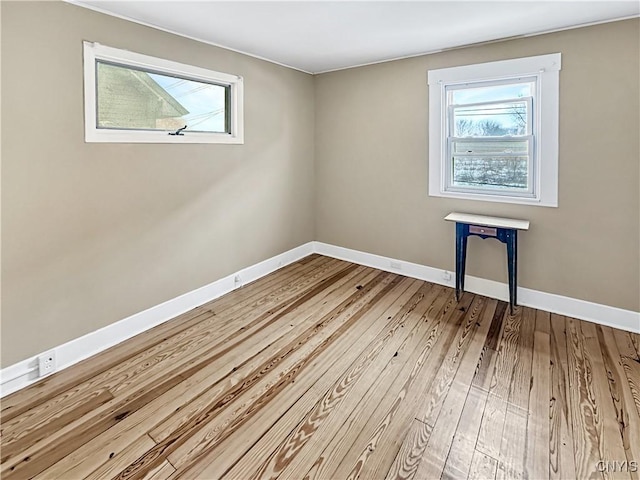 empty room featuring wood-type flooring and a healthy amount of sunlight