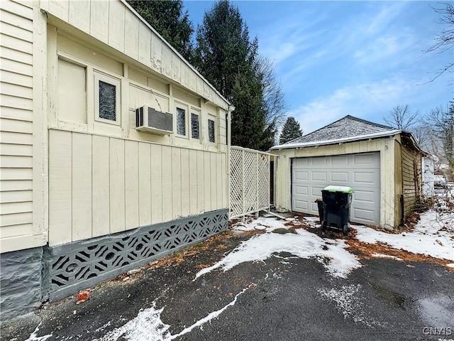 snow covered garage with cooling unit