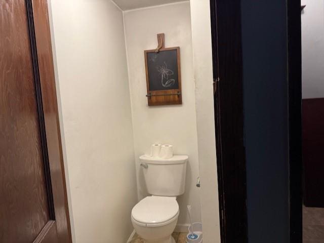 bathroom featuring baseboards and toilet