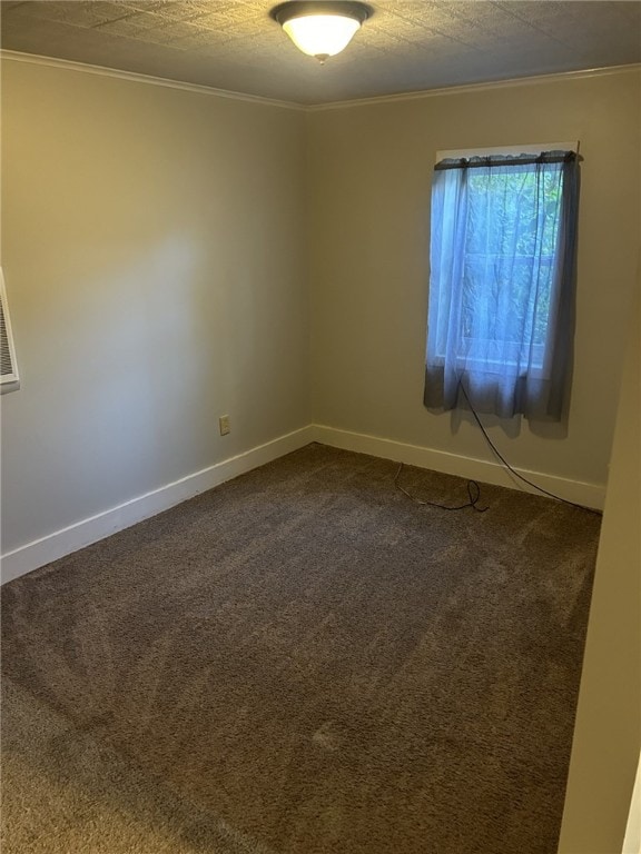 spare room with dark carpet, a textured ceiling, crown molding, and baseboards