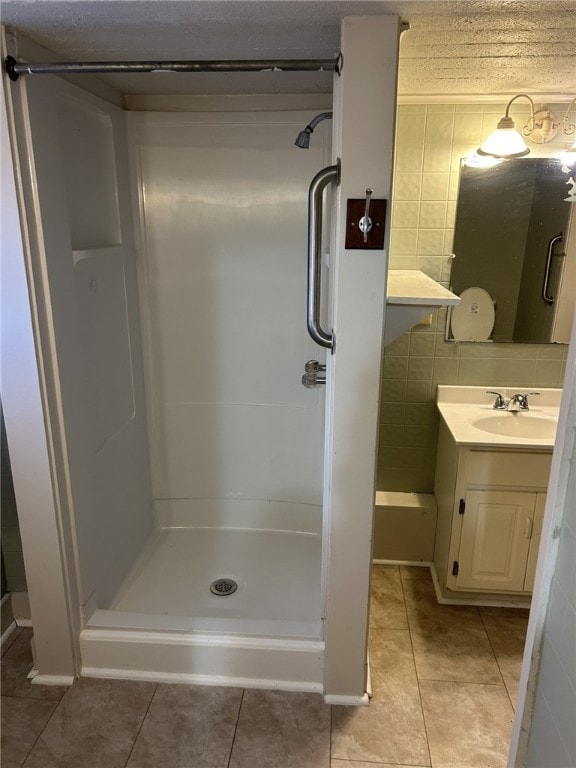 full bath with tile patterned flooring, a shower stall, and vanity