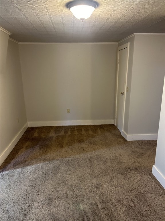 carpeted spare room with crown molding and baseboards