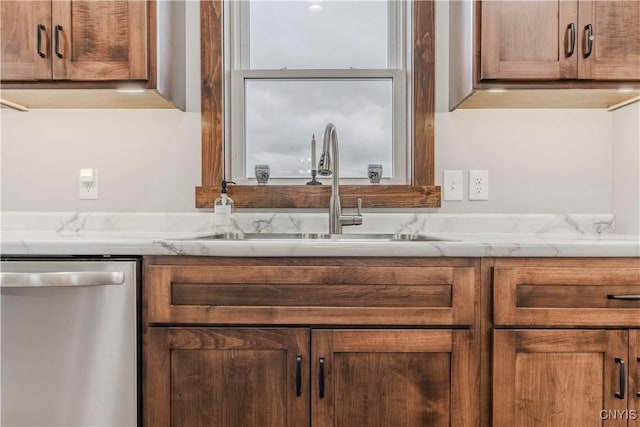 kitchen featuring dishwasher, light stone countertops, and sink