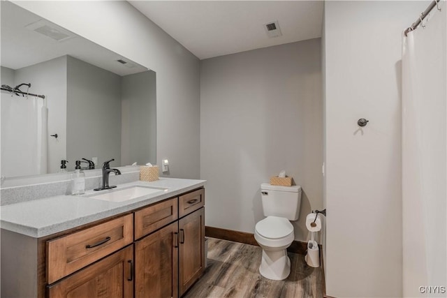 bathroom with hardwood / wood-style floors, vanity, and toilet