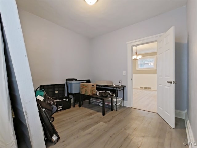 misc room featuring an inviting chandelier and light hardwood / wood-style flooring