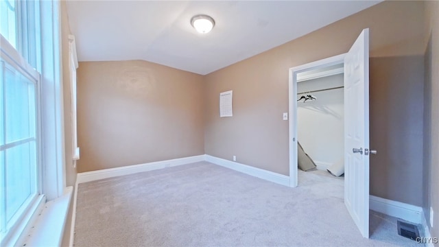 unfurnished bedroom with light carpet and vaulted ceiling