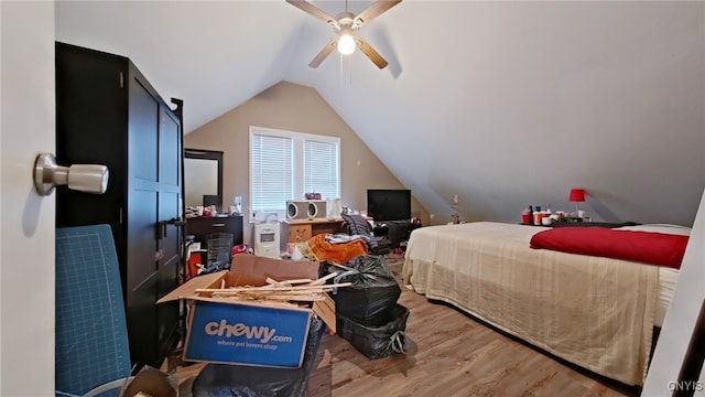 bedroom with ceiling fan, wood-type flooring, and lofted ceiling