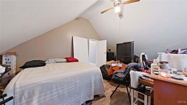 bedroom with light wood-type flooring, vaulted ceiling, and ceiling fan