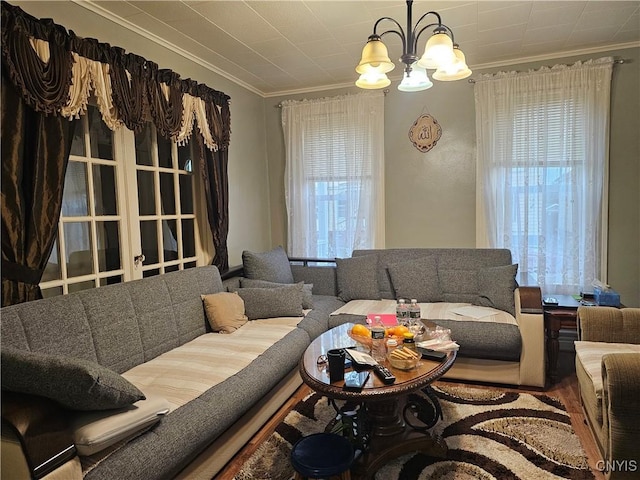 living room with crown molding, wood-type flooring, and a notable chandelier