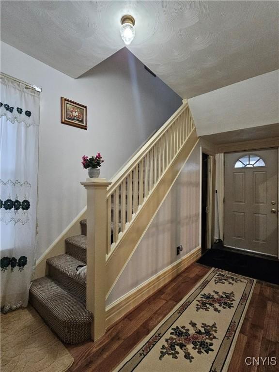 entryway with dark hardwood / wood-style flooring and a textured ceiling