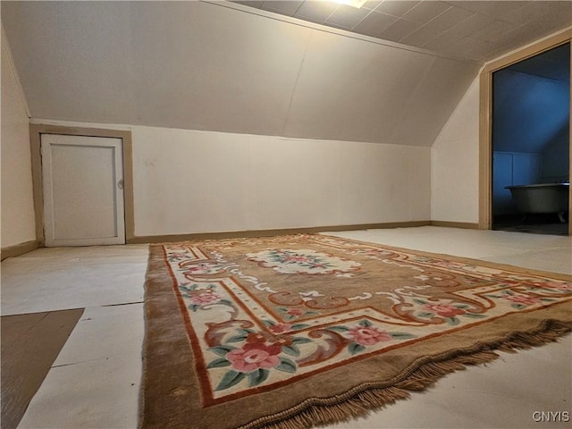 bonus room with concrete floors and vaulted ceiling